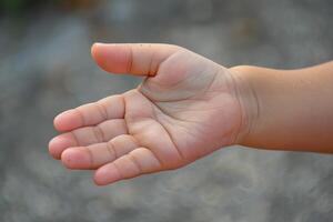 Child open hand asking for help on blur background photo