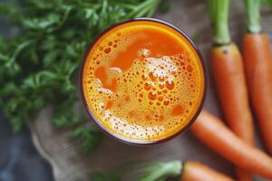Fresh carrot juice in glass on rustic background photo