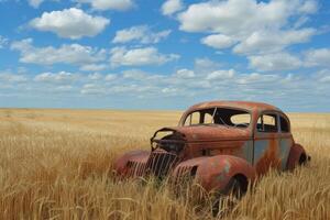 Rusting vintage car abandoned in golden wheat field photo