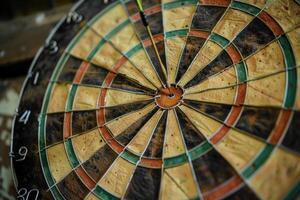 Detailed view of an old, worn dartboard with visible textures and color variations photo