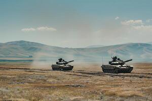 Military tanks maneuvering in desert terrain photo