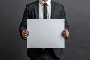 Cropped view of a businessman in a suit presenting an empty white board with copy space photo