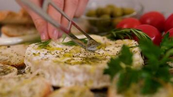 cutting soft cheese camembert or brie with knife closeup. creamy soft cheese inside. white mold cheeses with soft textures. wooden board video