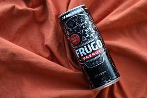 KYIV, UKRAINE - APRIL 20, 2024 Frugo energy drink in black can on orange fabric. Frugo is now owned by Food Care Poland photo