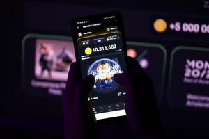 KYIV, UKRAINE - APRIL 20, 2024 Hamster Kombat telegram bot on smartphone screen. Hamster Kombat is a viral Telegram-based crypto game for earn HMSTR tokens by managing virtual crypto exchange photo