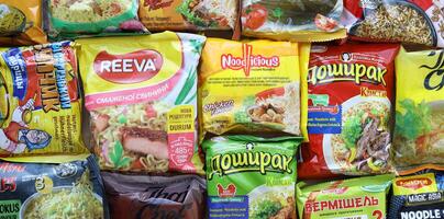 KYIV, UKRAINE - APRIL 20, 2024 Many packs of instant noodles for fast cooking by various brands and manufacturers photo