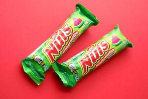KYIV, UKRAINE - APRIL 20, 2024 Nuts watermelon taste chocolate bar manufactured by Nestle company. Small chocolate with nuts and nougat in colorful wrapping photo