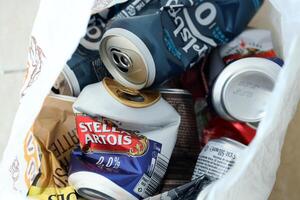 KYIV, UKRAINE - APRIL 20, 2024 Background of various crashed beer cans. Recycle aluminum metal crushed tin can waste photo