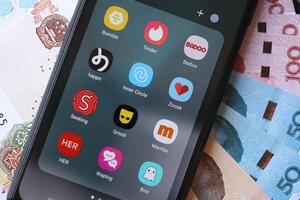 KYIV, UKRAINE - FEBRUARY 28, 2024 Dating apps icons on smartphone display and Chinese Yuan money photo