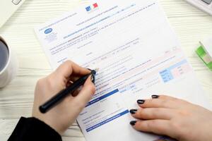 KYIV, UKRAINE - OCTOBER 31, 2023 Accountant fill french tax form CA12 Value added tax and similar taxes in end of tax period. Taxation and paperwork routine photo