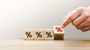 Hand Stacking Wooden Blocks with Percentage Signs, Representing Financial Growth, Interest Rates, and Investment Concepts in a Minimalist Setting, Emphasizing Economic Strategy and Profit Management photo