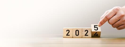 Transitioning from 2024 to 2025 with wooden blocks symbolizing target business for the upcoming year. This represents planning, investment, and innovation as ideas move from the end of 2024 new year photo