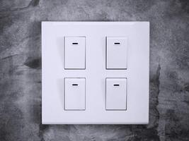 white light switch on a wall, Quad modern light switch on white wall with copy space, a light switch on gray wall, lighting switch, a plastic mechanical multiple buttons of white color installed photo