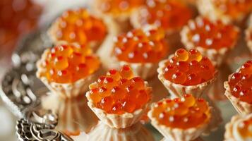 Close-up of tartlets filled with red caviar on a silver tray. photo