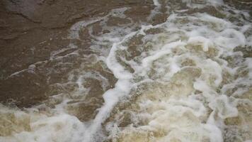 waves of water, water with a lot of white foam and bubbles. The water appears to be very choppy and rough, A waterway with a large amount of water flowing through it video