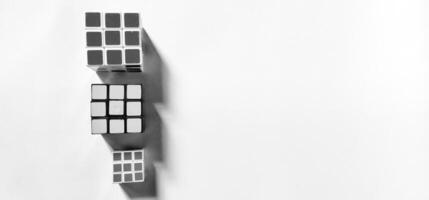 MAGELANG, INDONESIA. April 25th, 2024 - Black and white photo with an abstract photo concept as the background. Top view of three Rubik's photographed by giving a shadow effect to the object.