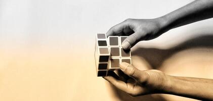 CENTRAL JAVA, INDONESIA. April 25th, 2024 - Man holding rubik's cube, brain training. The Rubik's Cube puzzle on white background morning sunlight concept. photo