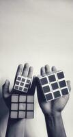MAGELANG, INDONESIA. April 25th, 2024 - Man holding rubik's cube, the rubik's cube puzzle shadow concept on white background. photo