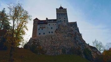 Bran, Romania, 2023 - Beautiful castle Bran the concealment on vicious Count Dracula. Low angle view of the historic building in autumn nature. video