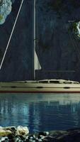 White yacht anchored in a bay with rocky cliffs video