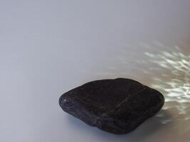 Rocks and reflections on a white background for a minimalist product background. photo