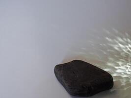 Rocks and reflections on a white background for a minimalist product background. photo