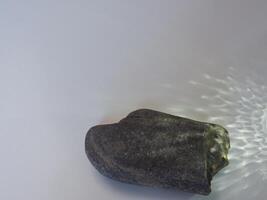 Rocks and reflections on a white background for a minimalist product background. photo
