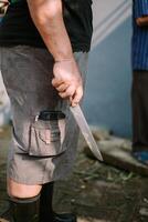 A man holds a sharp knife, ready for the sacrificial slaughter for Eid. photo