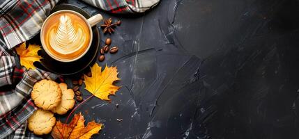 Autumn background with plaid, chocolate chip cookies and coffee cup with foam leaf on black table top view copy space banner autumn concept photo