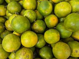 a large pile of green and yellow oranges photo