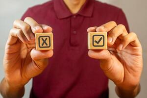 Man holding wooden blocks with Yes No icon or correct wrong icon. Yes Or No choice. photo