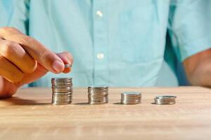 Man stacking and counting coins on the table photo