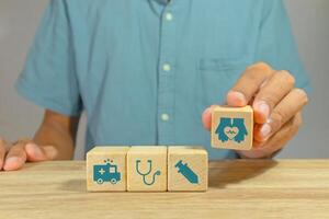 Man holding wooden blocks with healthcare medical icon photo