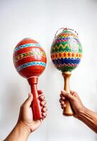 two people holding maracas with colorful traditional hispanic designs photo