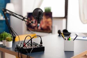 Microphone and mixer for podcast of famous creator. Influencer recording social media content with production microphone in professional home studio with modern equipment photo