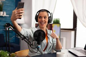 Woman blogger, vlogger portrait taking pictures of herself on smartphone. Content creator filming for fashion and beauty review, having fun on social media platform while taking selfie photo