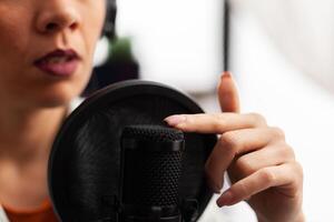 Close up of vlogger tapping microphone before making youtube . Influencer with recording professional equipment filming herself and having fun using technology to connect with public. photo