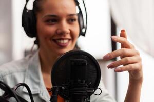 Close up of vlogger speaking at podcast microphone gesturing during life vlog. Social media content creator recording fashion for online channel sharing advices for followers community photo