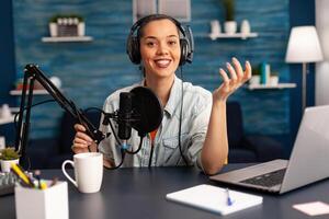 Blogger influencer recording blog looking at professional camera at online talk show home studio. Social media content creator making series for her channel, streaming online broadcast photo