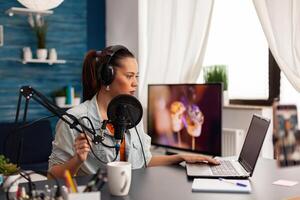 Creative vlogger making online conversation with her audience for new concept vlog. Recording social media content with production headphones, digital web internet streaming station photo