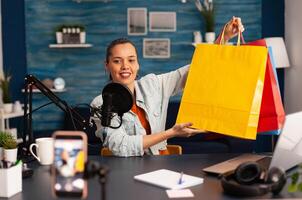 Social media star doing present giweaway for loyal subscribers. Creative content creator making blog concept speaking and looking at professional camera in home studio podcast photo