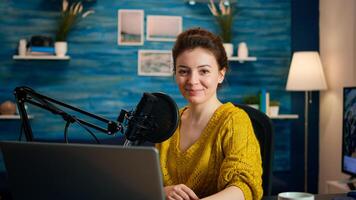 Portrait of vlogger looking at camera and smiling before starting live vlog, recording podcast. On-air online production internet broadcast show host streaming blog content from studio photo