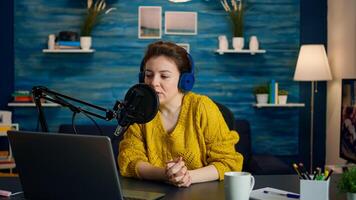 Influencer discussing with fan during live on social media recording new vlog in living room. On-air online production internet broadcast show host streaming live content, blogger during livestreaming photo