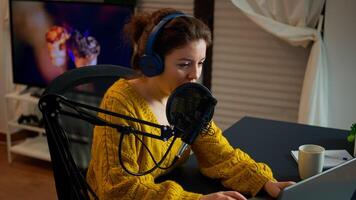 Blogger speaking at microphone with followers livestreaming typing on laptop. Online show On-air production internet broadcast host streaming live content, recording digital social media communication photo