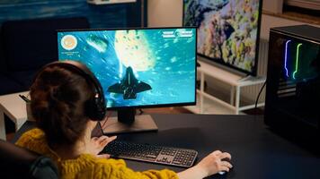 Gamer playing shooter games with other players late at night during gaming championship. Pro esport team player streamer during e-game tournament on powerful RGB computer, using streaming technology photo