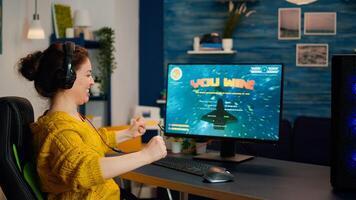 Joyful gamer celebrates victory winning shooter online game on powerful personal computer. Online streaming cyber performing during gaming tournament using technology network wireless photo