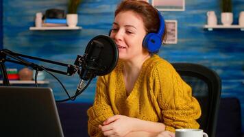 Woman vlogger recording to camera tutorial about lifestyle in home podcast studio during livestreaming. On-air online production internet broadcast show host streaming live content for social media photo