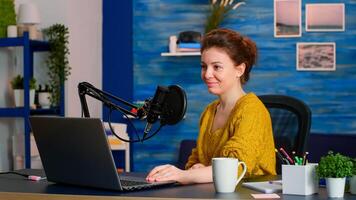 Portrait of caucasian vlogger working in cozy studio, smiling at camera ready to start new podcast show. On-air online production internet broadcast show host streaming web content record digital blog photo