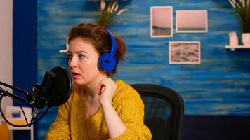 Vlogger checking microphone sound with finger, starting livestreaming sitting in home podcast studio. On-air online production internet broadcast show host streaming live content for social media photo