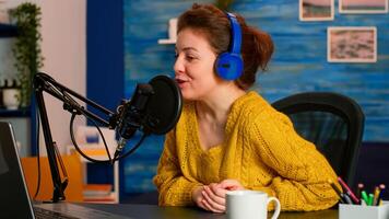 Influencer host talking and gesturing while recording vlog in home studio podcast. On-air online production internet broadcast show host streaming live content for social media photo